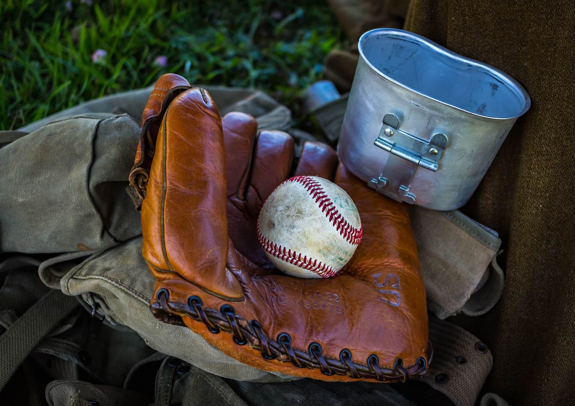 A baseball resting in an old leather mitt